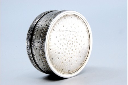  Caixa de comprimidos em prata guilhochada de forma circular e tampa amovível.